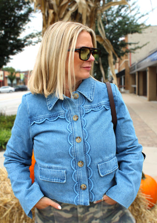Woman wearing the Marcie medium wash denim jacket with scallop trim and button front