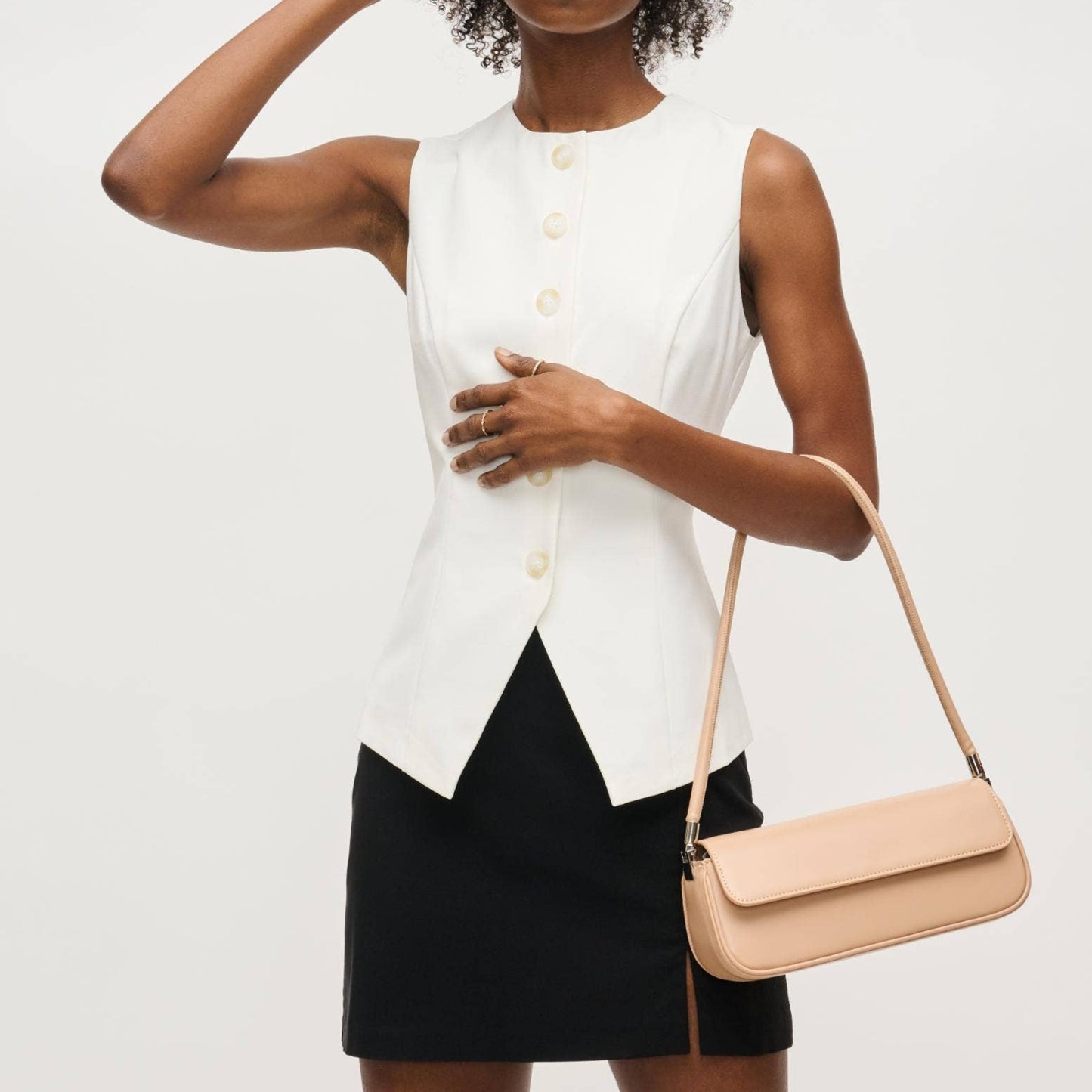 Model wearing a sleeveless white top and black skirt holding a nude baguette shoulder bag – Erin Rose Boutique