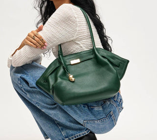 Woman carrying Monroe forest green satchel shoulder bag with gold-tone hardware