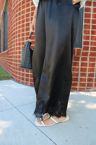 Side view of the Moonlight Satin Lace Long Pants showcasing the luxurious satin fabric and intricate lace hem detail.