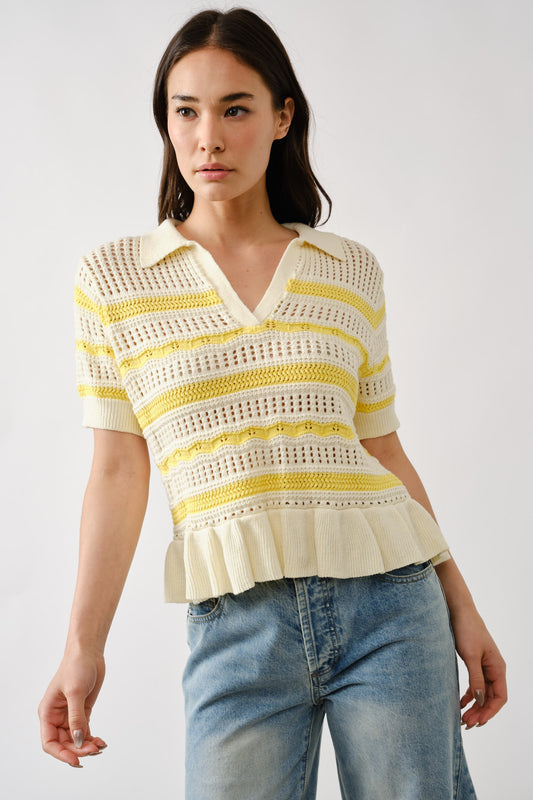 Woman wearing a yellow and cream open-knit striped sweater with ruffle hem