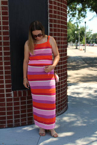 Sleeveless striped crochet knit set featuring vibrant pink and orange stripes styled with neutral heels and a white crossbody bag.