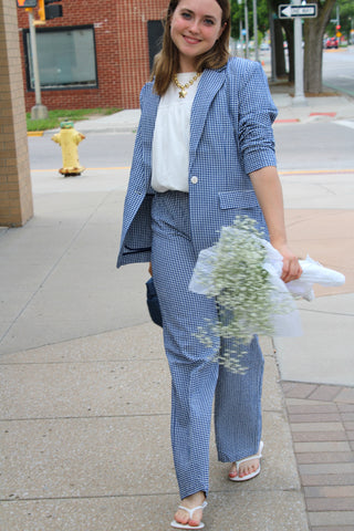 Oversized blue check blazer layered over a white top with match pants available at Erin Rose Boutique