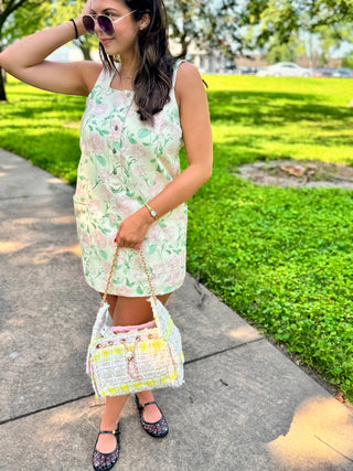 Woman wearing the Rosalie Floral Button Front Mini Dress with front patch pockets.