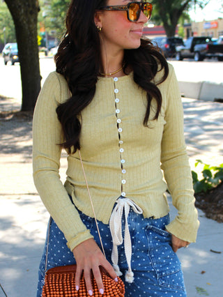 Soft sage green ribbed knit cardigan with long sleeves and a button-front closure.