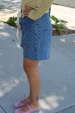 Side view of women's blue polka dot denim barrel shorts with oversized utility pockets and a rope drawstring waistband.