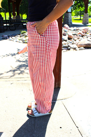 Side view of women's red gingham barrel-leg pants with an elastic waist and relaxed fit.