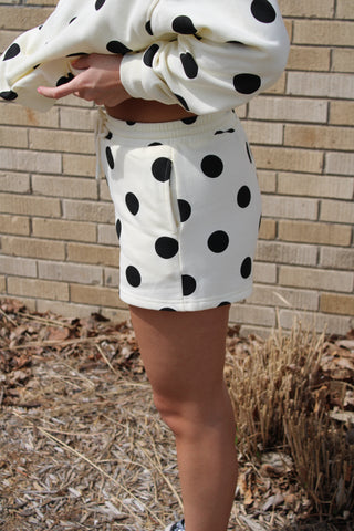 side view of woman wearing cream with black polka dot lounge shorts