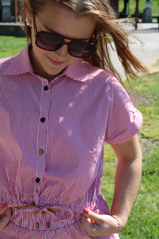 Red and white striped cropped button-up top with short sleeves, black buttons, and adjustable drawstring waist styled as a matching set