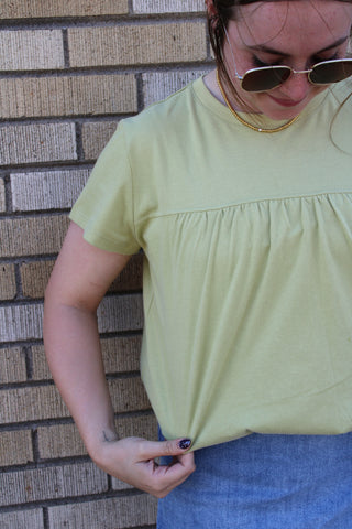 Tilly Bubble Hem Top in avocado green featuring a relaxed fit, gathered yoke detail, and bubble hem design.