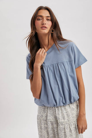 Tilly Bubble Hem Top in dusty blue featuring a relaxed fit, short sleeves, and flattering bubble hem silhouette available at ERB