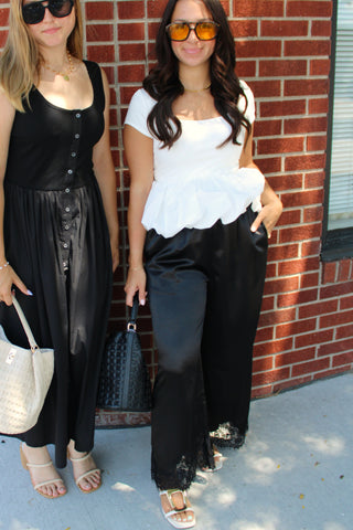 Women's white bubble hem top paired with black lace trim wide leg pants for a chic dressy outfit.