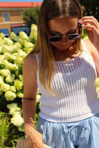 White sleeveless knit sweater tank paired with blue gingham shorts for a fresh summer outfit.