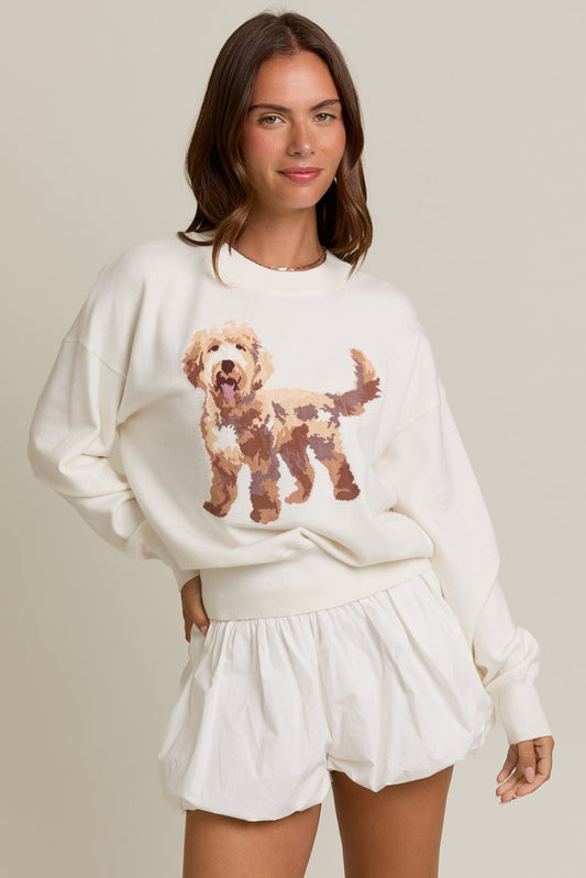 Woman wearing a white sweater with a dog graphic and matching shorts on a beige background