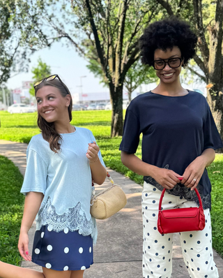 two women wearing a slub knit tee in light blue and navy with asymmetrical lace hems 