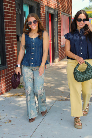 Women's dark wash button front denim vest styled with floral jeans