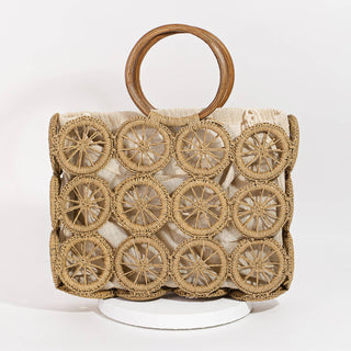 Boho-style woven raffia handbag featuring a unique circular wheel pattern overlay, natural linen lining, and round wooden handles, perfect for summer outings or beach days.