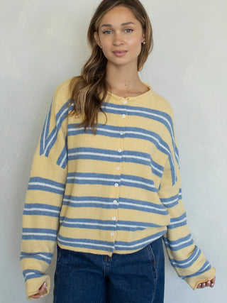 Woman wearing a yellow and blue striped long-sleeve piper cardigan against a plain background