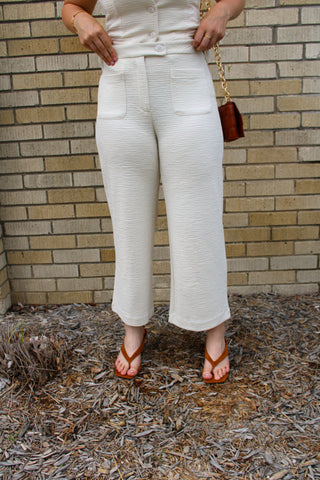 Women's textured straight-leg trousers featuring front patch pockets and a polished silhouette.